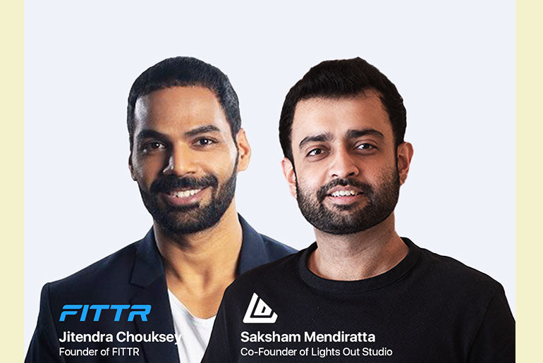 Two men smiling against a light background. One wears a dark blazer, the other a black t-shirt. Text shows their names and roles at FITTR and Lights Out Studio.